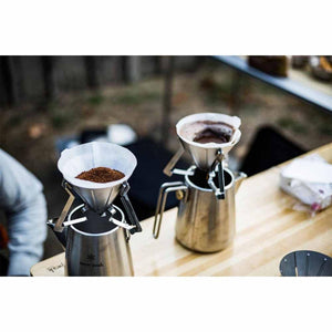 Two Snow Peak stainless steel coffee drippers on kettles with paper filters and coffee grounds