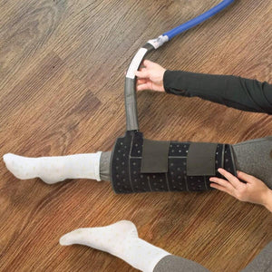 Person applying a black compression therapy wrap to their lower leg