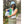 Woman wearing a light blue bucket hat and vest over a green top and striped skirt in a forest setting