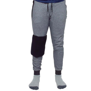 Person wearing grey joggers with a black knee brace on the right leg