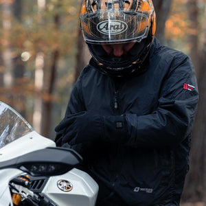 Motorcyclist wearing a Venture Heat jacket and gloves standing by a motorcycle