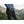 Person wearing black Fjallraven trousers with side zip pocket and blue jacket in mountain landscape