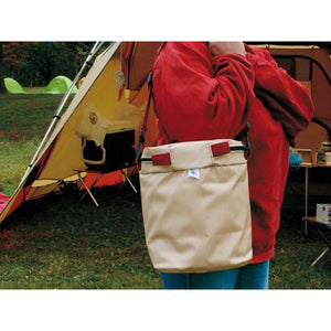 Person wearing a beige Snow Peak shoulder bag at a campsite
