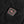 Black square power button with red R logo on black fabric