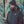 Man wearing a black Ravean puffer jacket and beanie looking at a smartphone
