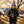 Man wearing ActionHeat Rams branded jacket and beanie holding a football at a tailgate party