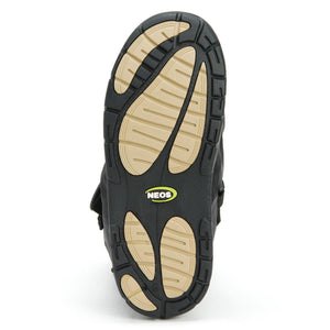 Black and tan treaded rubber outsole of a Neos overshoe