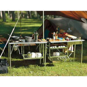 Snow Peak IGT camping kitchen setup with stove and storage baskets on a grassy field