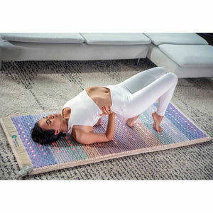 Person performing yoga bridge pose on a HealthyLine infrared therapy mat