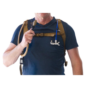 Person wearing a hydration backpack with a blue tube and white nozzle attachment
