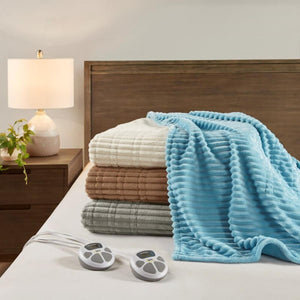 Stacked Serta heated blankets in blue white brown and grey with two digital controllers on a bed