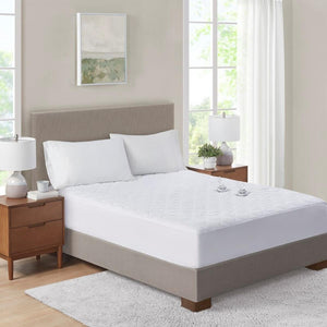 Serta white quilted mattress protector on a bed with two pillows and bedside tables