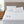 White quilted electric mattress pad with two handheld controllers on a bed with white pillows