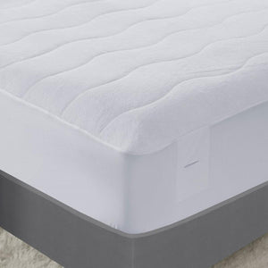 Serta white quilted mattress pad on a bed