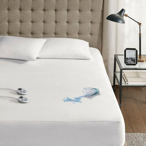 Serta waterproof mattress protector on a bed with a spilled glass of water