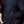 Close up of a person wearing a black fleece zip up jacket with a white logo on the chest