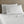 White bed sheets and two pillows against a wooden headboard