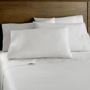 Shavel white bed sheets and pillowcases on a bed with a wooden headboard
