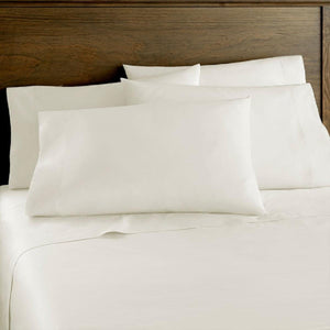 Shavel white bed sheets and pillowcases on a bed with a wooden headboard