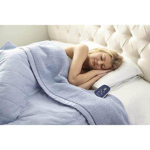 Person sleeping under a blue heated blanket with a digital controller