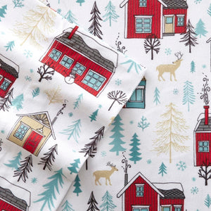Shavel flannel sheet pattern with red houses, deer, and pine trees on white background