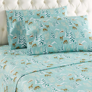 Shavel bed sheets featuring a teal winter forest pattern with deer and cabins