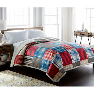Shavel plaid patchwork comforter with white sherpa reverse on a bed