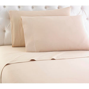 Shavel beige bed sheet set with two pillows against a tufted headboard