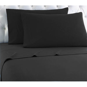 Shavel black sheet set with two pillows on a white tufted headboard