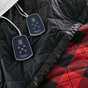 Two Shavel Home Products digital controllers on a black and red plaid quilted electric blanket