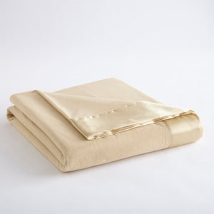 Folded beige fleece blanket with satin trim