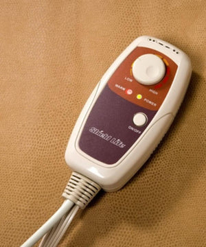 Shield Life handheld temperature controller with dial and power button on a textured tan surface