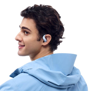 Person wearing light blue Shokz open ear headphones