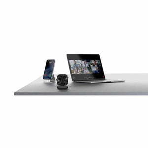 Smartphone on stand and wireless earbuds in charging case next to laptop displaying a video conference
