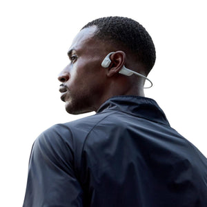 Person wearing white Shokz bone conduction headphones