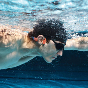 Swimmer wearing Shokz bone conduction headphones underwater