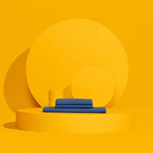 Folded blue bed sheets on a yellow circular platform