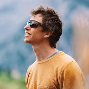 Man wearing Smith sunglasses and a yellow shirt looking up