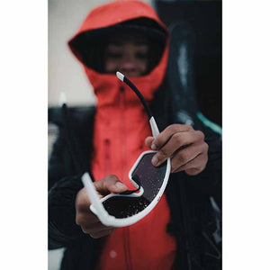 Person in red hooded jacket holding Smith Optics sunglasses with white frames
