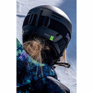 Back view of a person wearing a black Smith Optics Method ski helmet and goggles on a snowy slope