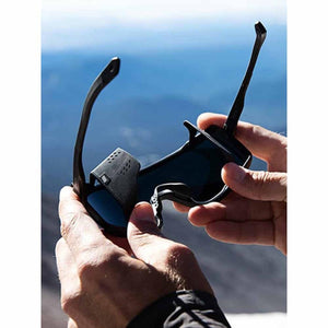 Hands holding black glacier sunglasses with side shields