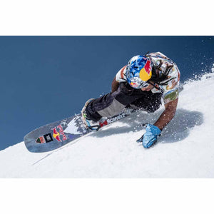 Snowboarder wearing a Smith Optics helmet carving on a snowy slope