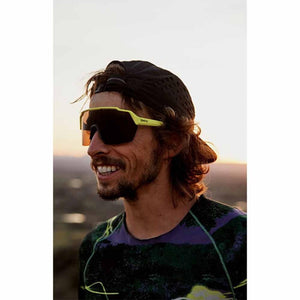 Person wearing Smith Optics yellow frame sunglasses and a black cap