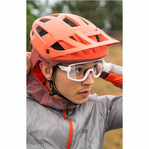 Person wearing a Smith Optics orange cycling helmet and white clear lens glasses