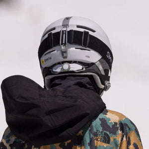 Back view of a person wearing a white Smith Optics Vida ski helmet and goggles