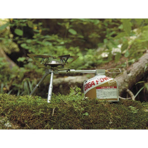 Snow Peak GigaPower stove attached to a fuel canister on a mossy log