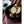 Whole and halved brown onions in a black bowl on a red and white checkered cloth
