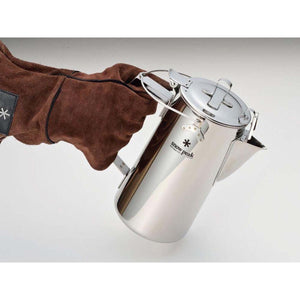 Hand in brown leather glove holding a stainless steel Snow Peak coffee percolator