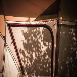 Interior view of a Snow Peak tent showing mesh windows with tree shadows cast on the fabric