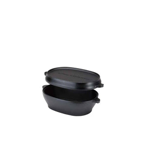 Black cast iron oval dutch oven with lid slightly lifted